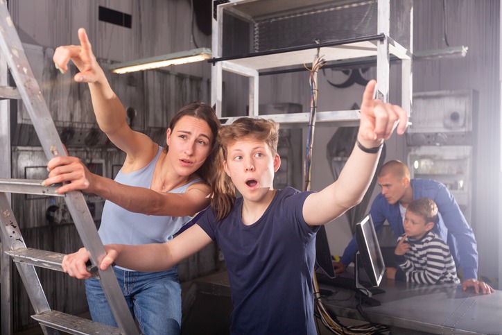 Teen boy with mother reaching for something in quest room