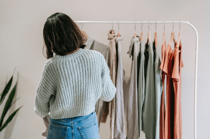 woman-against-rack-with-assorted-clothes-in-building