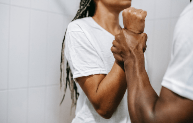 faceless-muscular-ethnic-man-grabbing-wrist-of-girlfriend-during-dispute