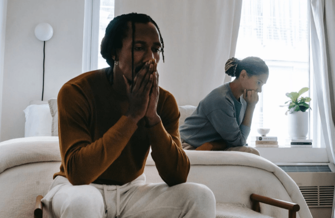 unhappy-black-couple-sitting-on-bed-after-having-argument