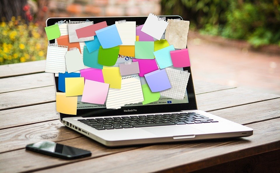 a laptop with lots of sticky notes on it