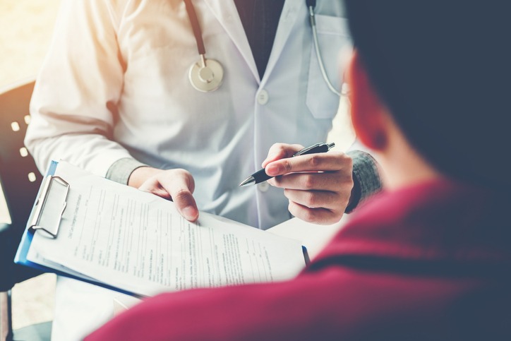 Doctors and patients sit and talk. At the table near the window in the hospital