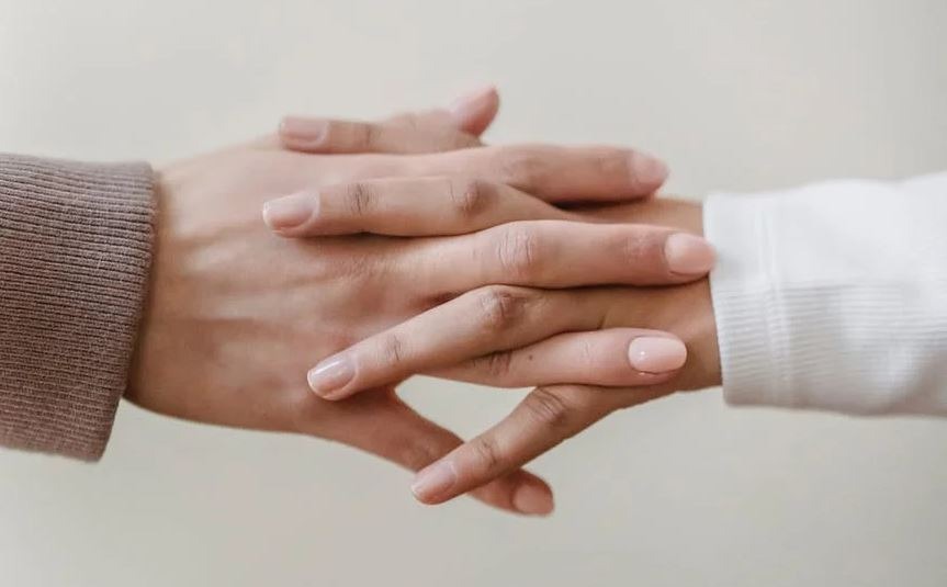 faceless-girlfriends-holding-hands-near-wall