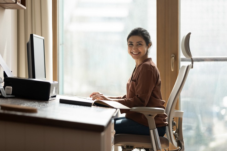 Happy biracial businesswoman freelancer sit by computer