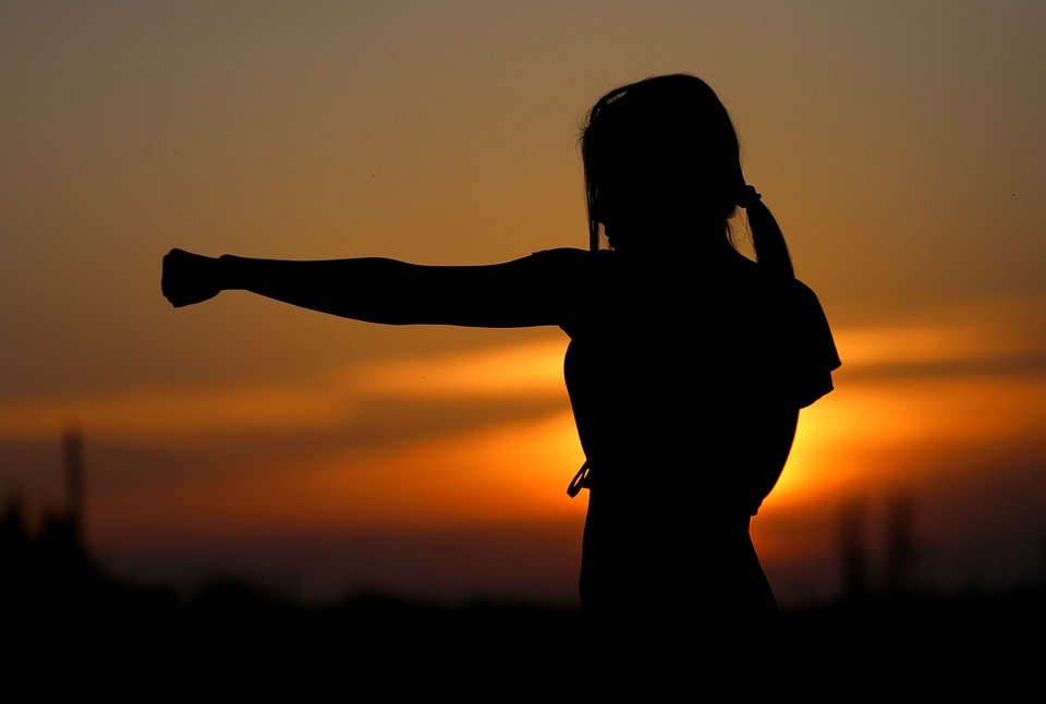 woman showing strength at sundown