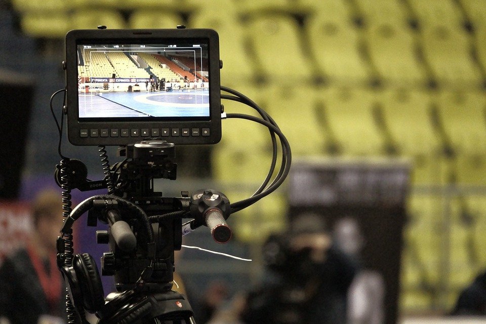 a camera recording a basketball game in a stadium