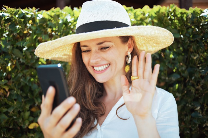 happy woman in shirt having video meeting on smartphone