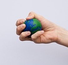 Hand squeezing an Earth-shaped stress ball