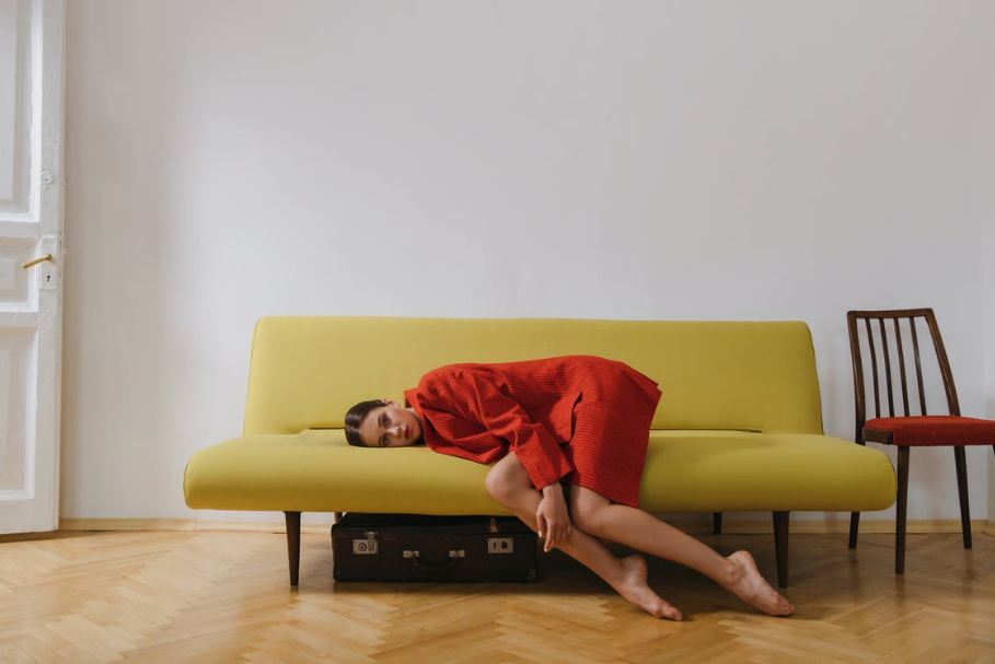 woman-in-red-dress-lying-on-yellow-couch