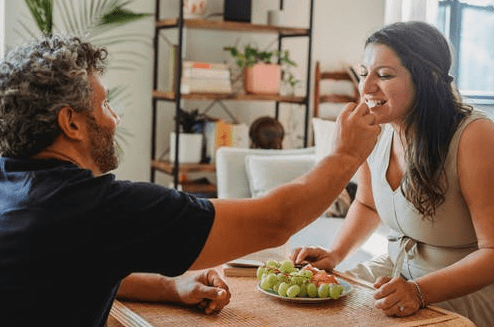 Husband feeding wife with fruits